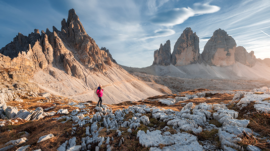 Girl with backpack on the trail in mountains