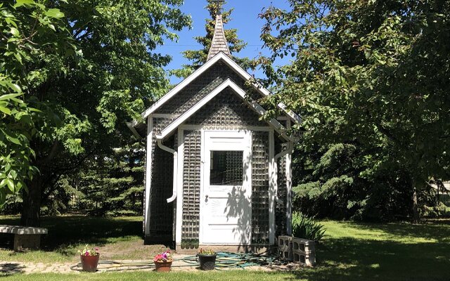 Image showing a small church built out of bottles surrounded by trees.